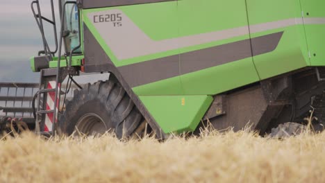 Primer-Plano-De-Cosechadora-Verde-Cosechando-En-Un-Campo-De-Trigo-En-Un-Día-Soleado