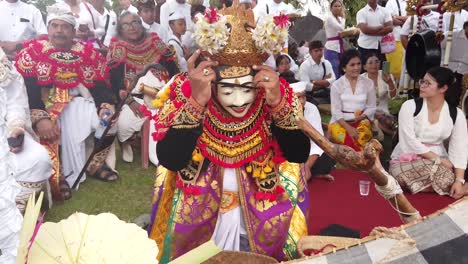 Artista-Se-Viste-Para-Danza-Balinesa-Teatro-Drama-Acto-Enmascarado-Topeng-Ceremonia-Del-Templo-De-Bali-Para-La-Religión-Hindú,-Trajes-Coloridos-Y-Gente-Reunida