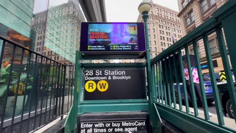 POV-Pan-Down-Shot-Of-Entrance-To-28-Street-Station-In-New-York-Then-Proceeding-To-Walking-Down-Steps