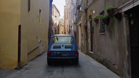 Auto-Fährt-Auf-Schmaler-Kopfsteinpflasterstraße-Durch-Häuser-In-Pitigliano,-Italien