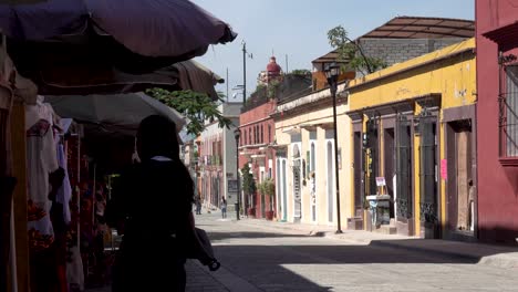 Man-carrying-a-sunshade-umbrella-through-a-commercial-clothing-store-on-the-street,-Medium-shot