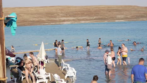 Gruppe-Von-Menschen,-Die-Auf-Dem-Wasser-Im-Toten-Meer-In-Israel-Schwimmen