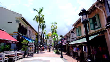 2-sides-of-a-2-storey-colonial-buildings-with-a-golden-mosque,-people-and-cloudy-sky