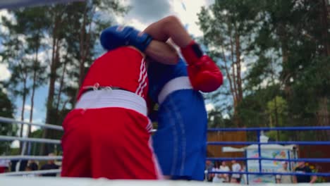 Dos-Boxeadores-En-El-Ring-De-Boxeo-Peleando,-El-árbitro-De-Pie-Junto-A-Los-Luchadores,-Una-Toma-Cinematográfica