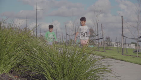 Amidst-the-public-playground,-young-boys-eagerly-run-after-a-toy-car,-their-faces-beaming-with-excitement-and-pure-joy-as-they-embrace-the-exhilarating-chase