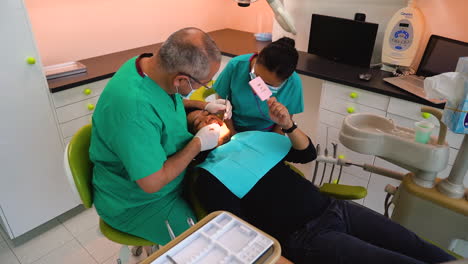 Toma-En-Cámara-Lenta-De-Un-Dentista-Y-Una-Enfermera-Realizando-Un-Chequeo-Dental-A-Un-Paciente