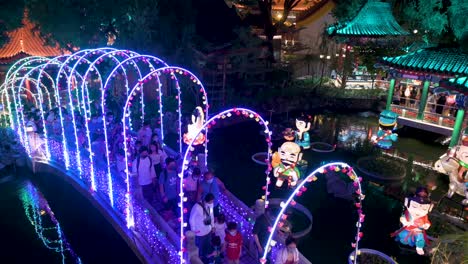 Los-Visitantes-Caminan-Por-Un-Puente-Decorado-Con-Luces-Mientras-Disfrutan-De-Un-Espectáculo-Nocturno-De-Faroles,-Que-Simboliza-La-Prosperidad-Y-La-Buena-Fortuna,-En-El-Templo-Wong-Tai-Sin-Durante-El-Festival-Del-Medio-Otoño.