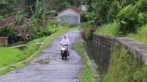 Chicas-Estudiantes-En-Motocicletas-Pasan-Por-Un-Camino-Rural-En-Las-Colinas-De-Garut,-Java-Occidental---Cámara-Lenta