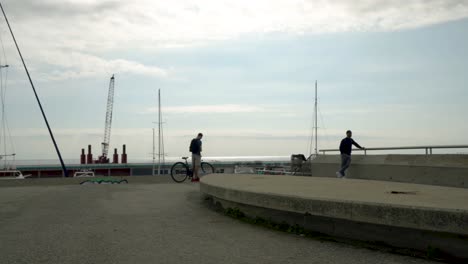 Ciclista-Y-Hombre-Local-Parado-En-El-Muelle-Del-Pequeño-Puerto-De-Barcelona,-España