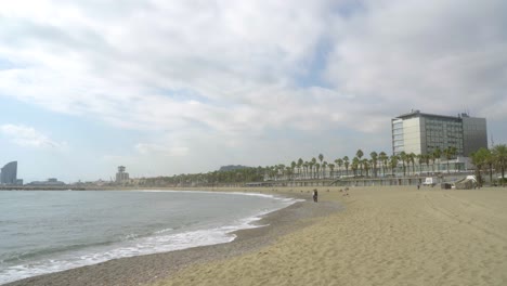 Wide-shot-Barceloneta-Beach-on-cloudy-day-in-Barcelona,-Spain