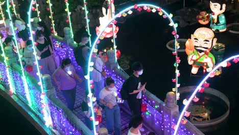 Chinesische-Besucher-Aus-Der-Vogelperspektive,-Die-über-Eine-Mit-Lichtern-Geschmückte-Brücke-Gehen-Und-Während-Des-Mittherbstfestes-Eine-Nächtliche-Laternenshow-Im-Wong-Tai-Sin-Tempel-Genießen