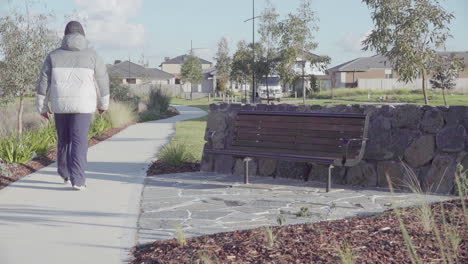 In-the-peaceful-neighborhood-parks,-a-man-leisurely-walks-amidst-the-surroundings-of-new-suburban-developments