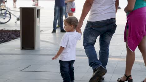 Family-walking-around-at-Praca-Maua,-holding-the-hand-of-a-child,-in-the-center-of-Rio-de-Janeiro,-Brazil,-on-a-Sunday-afternoon