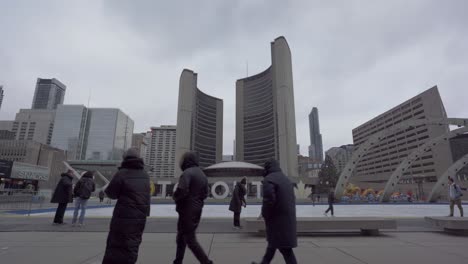 People-Ice-Skating-And-Visiting-Toronto-City-Hall,-Nathan-Phillips-Square