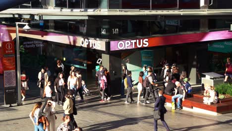 Vista-Inclinada-Hacia-Abajo-De-La-Tienda-Insignia-De-Optus-A-Lo-Largo-Del-Centro-Comercial-Queen-Street-De-Brisbane,-Repleta-De-Estudiantes-Y-Peatones-En-El-Centro-De-La-Plaza-En-El-Distrito-Central-De-Negocios