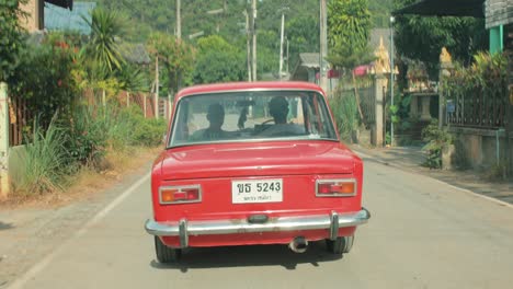 Coche-Rojo-Clásico-Que-Se-Aleja-En-La-Distancia-Con-Montañas-De-Bosques-Verdes-En-Tailandia