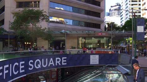 Office-workers-taking-the-escalator-down-to-the-food-court-at-post-office-square-during-lunch-time-rush-hours,-Brisbane's-central-business-district,-static-shot