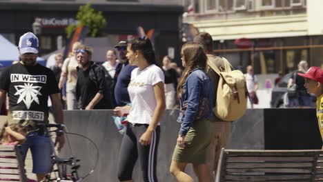 Toma-En-Cámara-Lenta-De-Gente-Caminando-Y-Divirtiéndose-En-La-Plaza-Del-Pueblo-En-Un-Día-Soleado