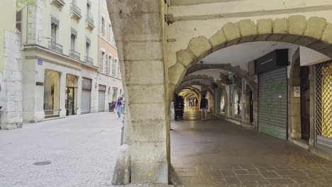 En-Las-Calles-De-Annecy,-Pasajes-Con-Arcos-De-Piedra-Y-Peatones-En-Verano.