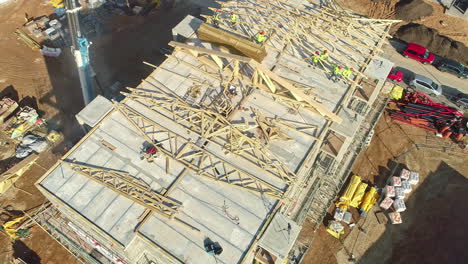 Luftaufnahme,-Die-Arbeiter-Auf-Einer-Sonnigen-Baustelle-Eines-Mehrfamilienhauses-Wegkippt