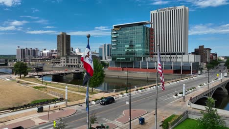 Iowa-flag-waving-in-front-of-Cedar-Rapids-skyline-during-bright-summer-day