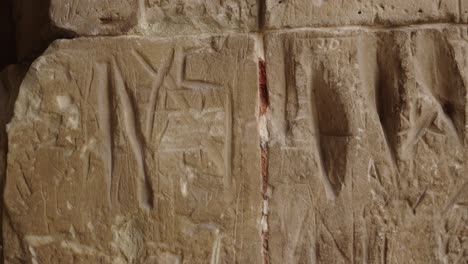 A-close-up-view-of-the-stone-wall-of-the-ghetto-in-Terezín-with-several-carved-inscriptions-containing-testimonies-of-former-prisoners