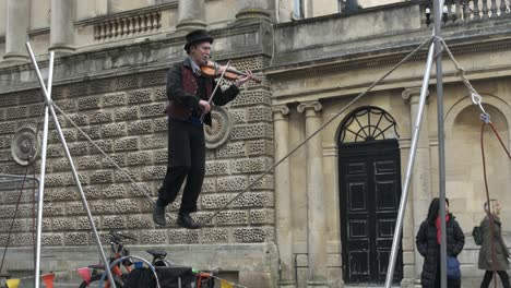 Un-Artista-Toca-Un-Violín-En-La-Cuerda-Floja-En-El-Centro-De-La-Ciudad