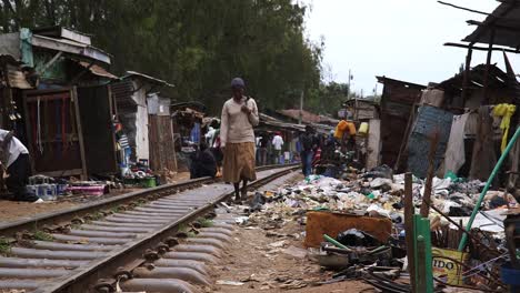 Men-and-women-walking-along-the-railway-in-the-slum-of-Kibera