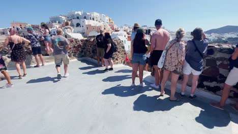 Oia-Santorini-Grecia-Isla-Viaje-Turístico-Paseo-Inmersivo,-Europa,-4k-|-Griego,-Egeo,-Mar,-Acantilado,-Océano,-Ciudad,-Vacaciones,-Compras,-Blanco,-Mármol,-Multitud,-Flores,-Viajero,-Gente,-Panorama,-Borde