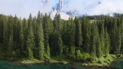 Reflection-at-Lake-Carezza-shot-on-a-drone-in-the-Italian-alps,-Dolomites-while-there-are-mountains-in-the-background