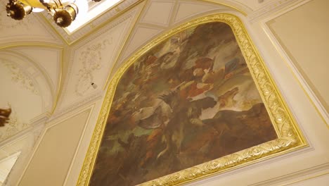 Enorme-Pintura-Mural-Interior-Con-Marco-Dorado-Cerca-De-Una-Linterna-Y-Una-Pequeña-Estatua