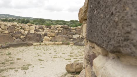 Footpring-of-a-Nuraghe-Barumini-in-Sardinia,-Italy-Tilting-shot-on-this-ancient-and-mysterious-building