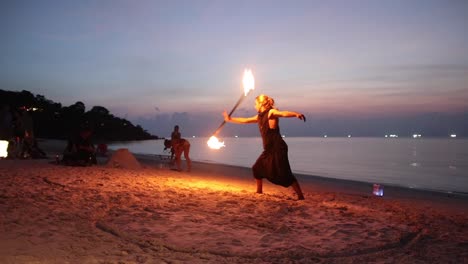 El-Hombre-Juega-Haciendo-Girar-Un-Palo-De-Fuego-Durante-La-Puesta-De-Sol-En-La-Playa-De-Haad-Yao,-Koh-Phangan