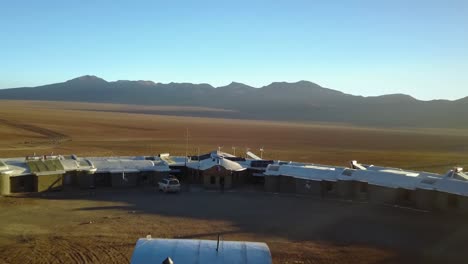 Aerial-drone-shot-away-from-people,-revealing-a-resort-and-the-nature-of-Andes-mountains,-on-a-sunny-day,-near-Uyuni-Salt-Flats,-in-Bolivia,-South-America