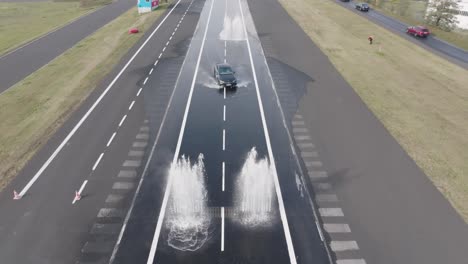 Auto-Manövriert-Auf-Nasser,-Rutschiger-Asphaltstraße-Und-Fährt-Durch-Ein-Wasserhindernis