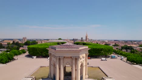 Toma-Aérea-Del-Orgullo-Gay-2023-Alrededor-De-Los-Concurridos-Jardines-De-Peyrou,-Volando-Sobre-La-Torre-De-Agua-En-Montpellier