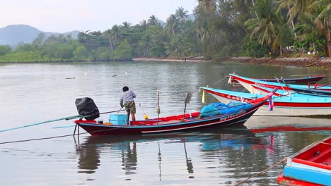 Fisherman-gets-ready-to-leave-the-bay-in-his-long-tail-boat-and-go-out-to-sea-to-catch-some-fish