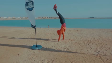 Young-Hijabi-Athlete-walking-on-hands-by-the-beach-of-north-coast---Slow-Motion