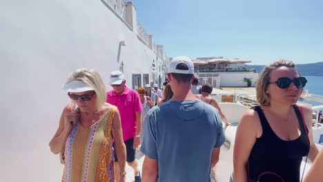 Oia-Santorini-Grecia-Isla-Viaje-Turístico-Paseo-Inmersivo,-Europa,-4k-|-Griego,-Egeo,-Mar,-Acantilado,-Océano,-Ciudad,-Vacaciones,-Compras,-Blanco,-Mármol,-Multitud,-Flores,-Viajero,-Gente,-Camino,-Pasar-Por-Alto