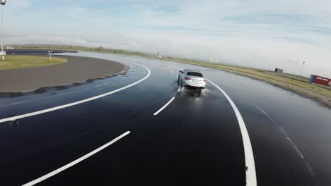 Aerial-follow-of-car-drive-on-wet-asphalt-track-and-lose-control-in-turn