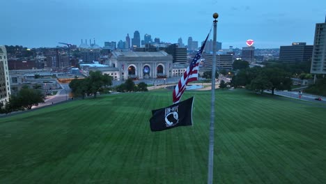 Bandera-Americana-Y-Bandera-De-Pow-Mia-Ondeando-En-El-Monumento-A-La-Libertad-Con-Vistas-A-Union-Station-Y-Al-Centro-De-La-Ciudad-De-Kansas-Al-Amanecer