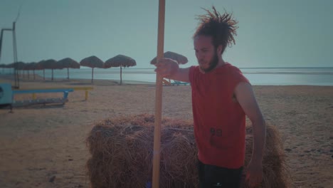 Male-Athlete-throw-spear-to-a-wooden-board-at-sunset---Front---Slow-Motion