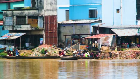 Local-Village-People-Rowing-Traditional-Boats-On-Polluted-River-In-Bangladesh