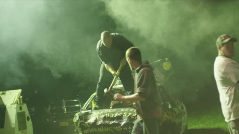 Man-Fixing-Demo-Derby-Car’s-Hood-With-Hammer