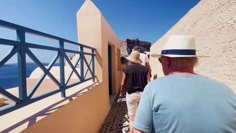 Oia-Santorini-Grecia-Isla-Viaje-Turístico-Paseo-Inmersivo,-Europa,-4k-|-Griego,-Egeo,-Mar,-Acantilado,-Océano,-Ciudad,-Vacaciones,-Compras,-Blanco,-Mármol,-Multitud,-Flores,-Viajero,-Gente,-Sombrero,-Ocupado