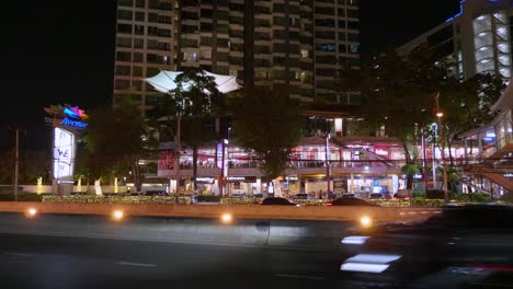 Vehicles-passing-by-at-the-opposite-side-of-a-popular-community-mall-in-the-middle-of-the-city-of-Bangkok,-Thailand