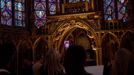 Vista-Cinematográfica-De-Turistas-Tomando-Fotografías-Del-Techo-De-La-Capilla-Superior-De-La-Iglesia-Sainte-chapelle-Con-Sus-Vidrieras-Azules-Y-Violetas,-Monumento-Nacional-De-Francia