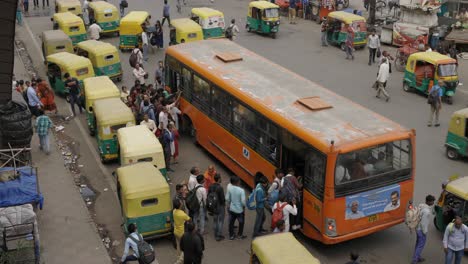 People-squeezing-into-bus-on-busy-road,-Delhi-India