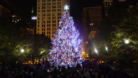 La-Gente-Está-Celebrando-Las-Vacaciones-De-Invierno-Cerca-Del-árbol-De-Navidad-En-El-Centro-De-Chicago-Con-Rascacielos-Al-Fondo.