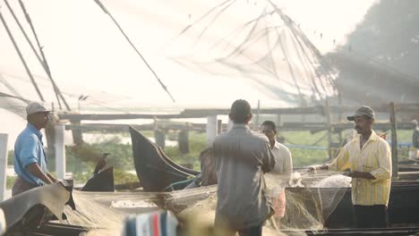 Local-fishermen-in-Kochi,-India-shaking-and-untangling-their-fishing-net---close-up